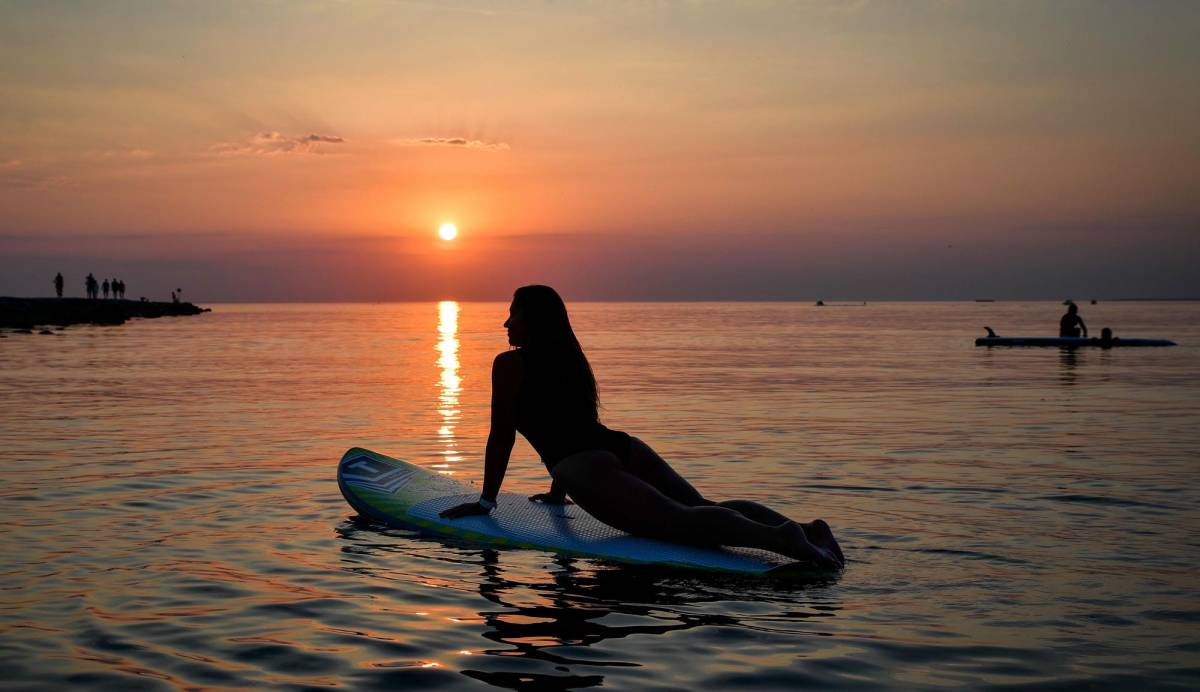 Pige der dyrker SUP yoga på Gardasøen