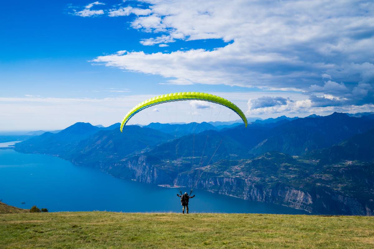 Een persoon die op een kliffrand staat en klaar is om te paragliden
